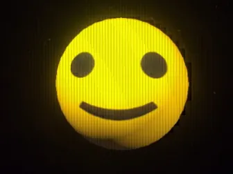 Smiley, a glowing yellow smiley face against a black background